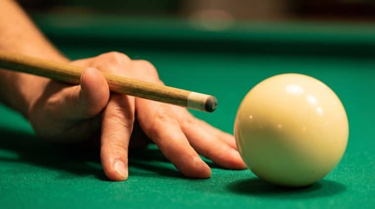 Main formant un chevalet ouvert sur le tapis de billard