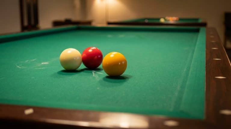 Trois billes de carambole sur tapis vert illustrant un carambolage